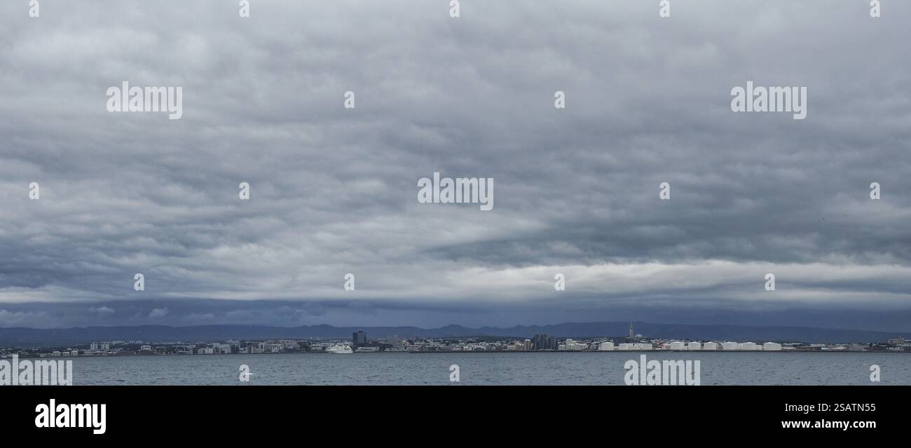 Wolkige Stimmung, Blick vom Meer auf die Skyline von Reykjavik, Reykjavik, Island, Europa Stockfoto