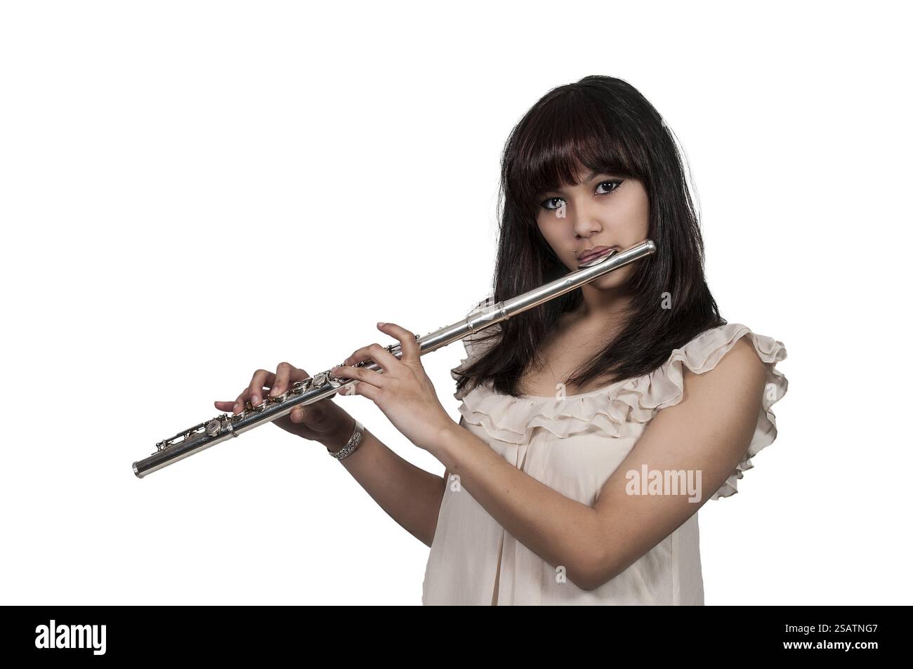 Schöne junge Frau, die das Instrument der Flöte spielt Stockfoto
