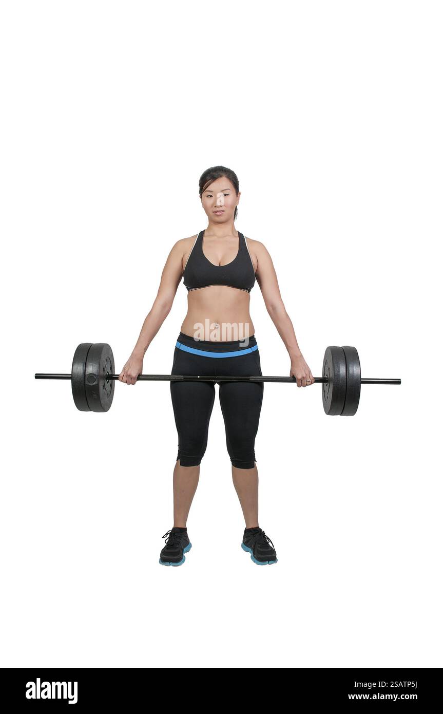 Schöne junge asiatische Frau, die Gewichte während eines Workouts benutzt Stockfoto