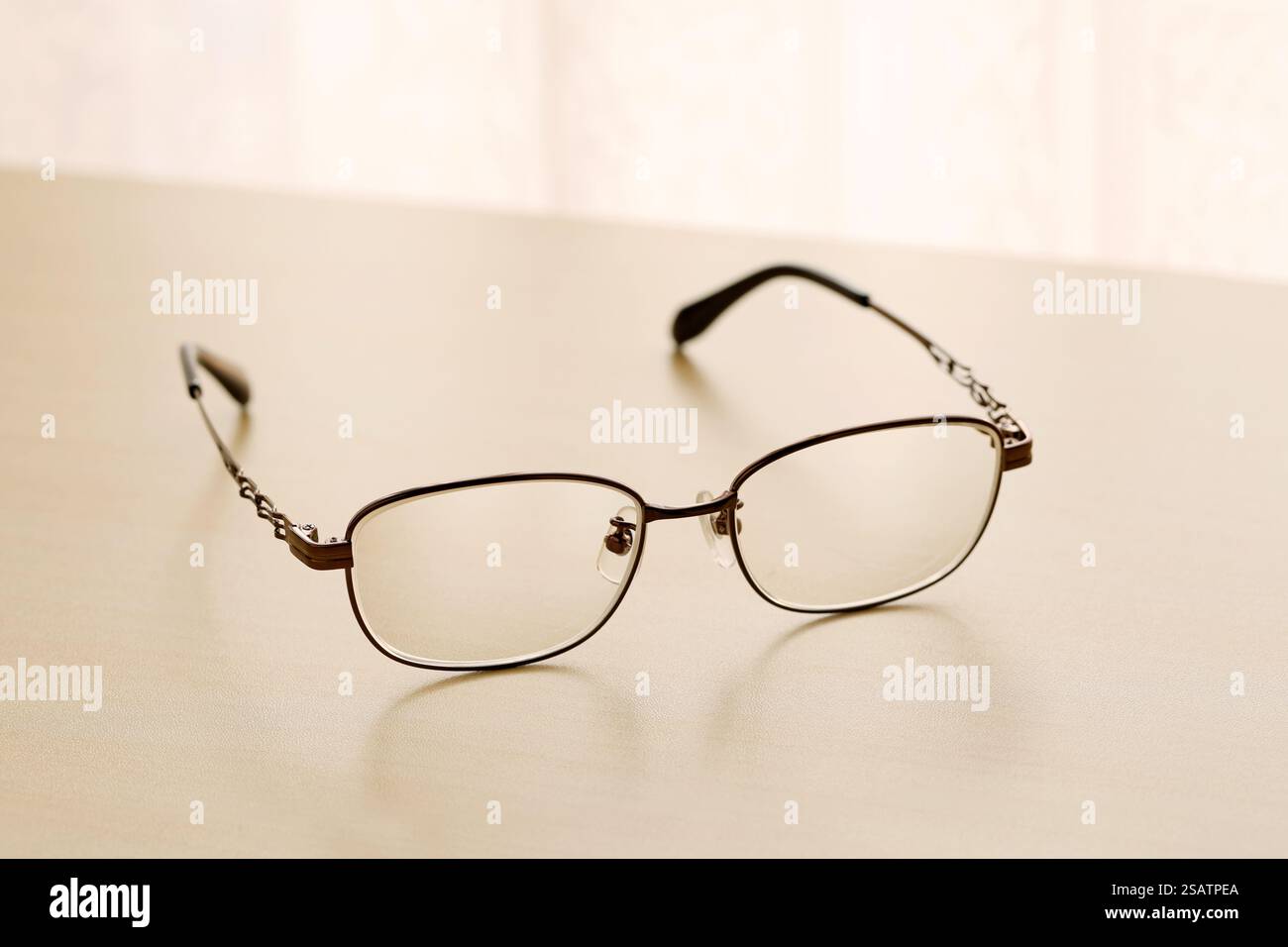 Augenbrille auf einem Holztisch am hellen Fenster Stockfoto