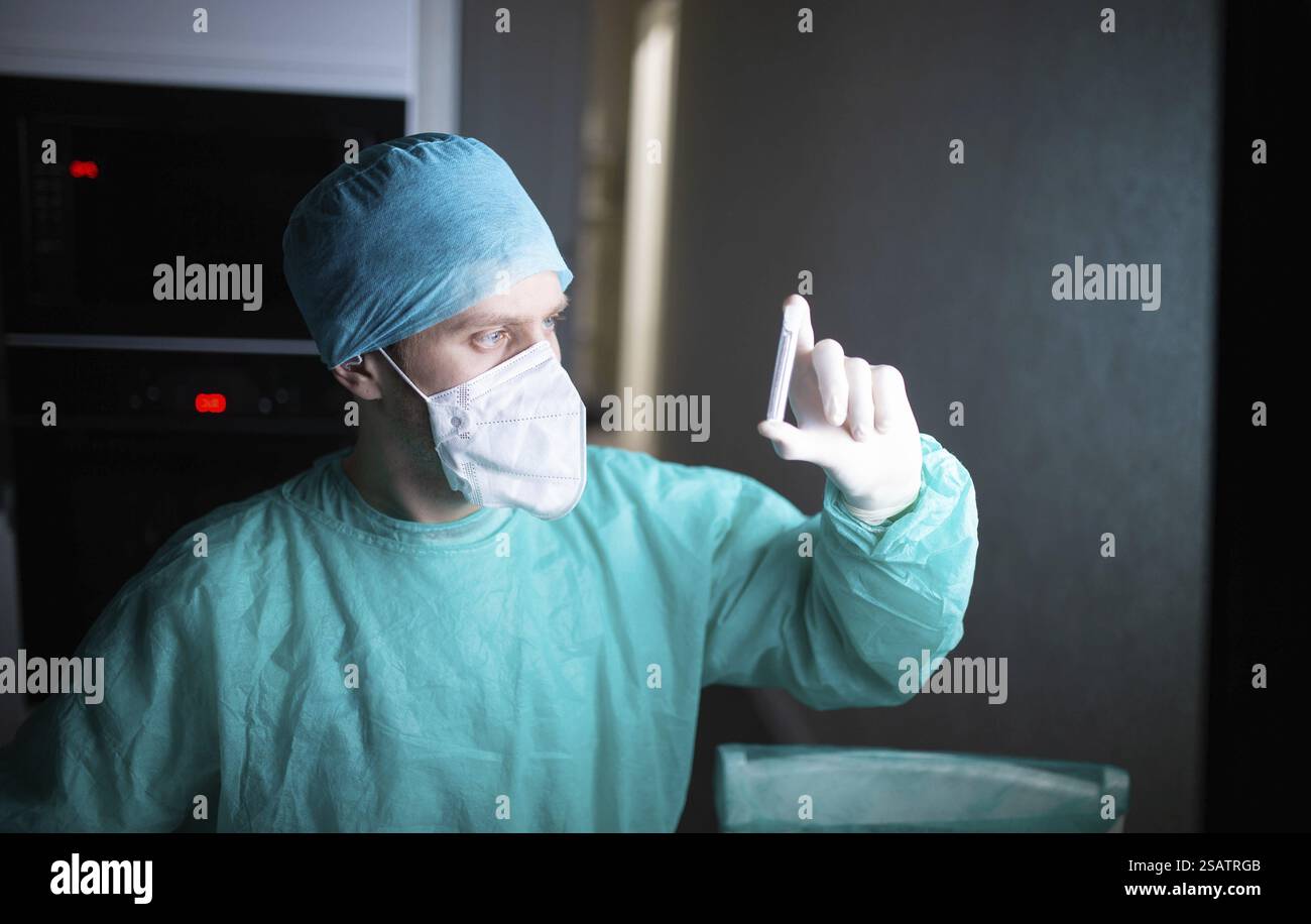 Arzt in Peelings und Maskenuntersuchung einer Laborprobe Stockfoto