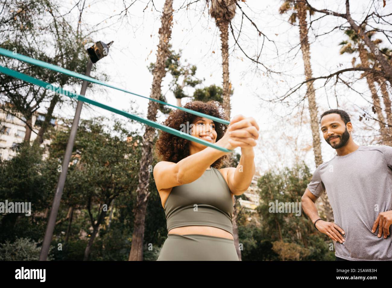 Zwei Personen, die in einem malerischen Park Fitnessaktivitäten mit Outdoor-Krafttraining absolvieren. Stockfoto