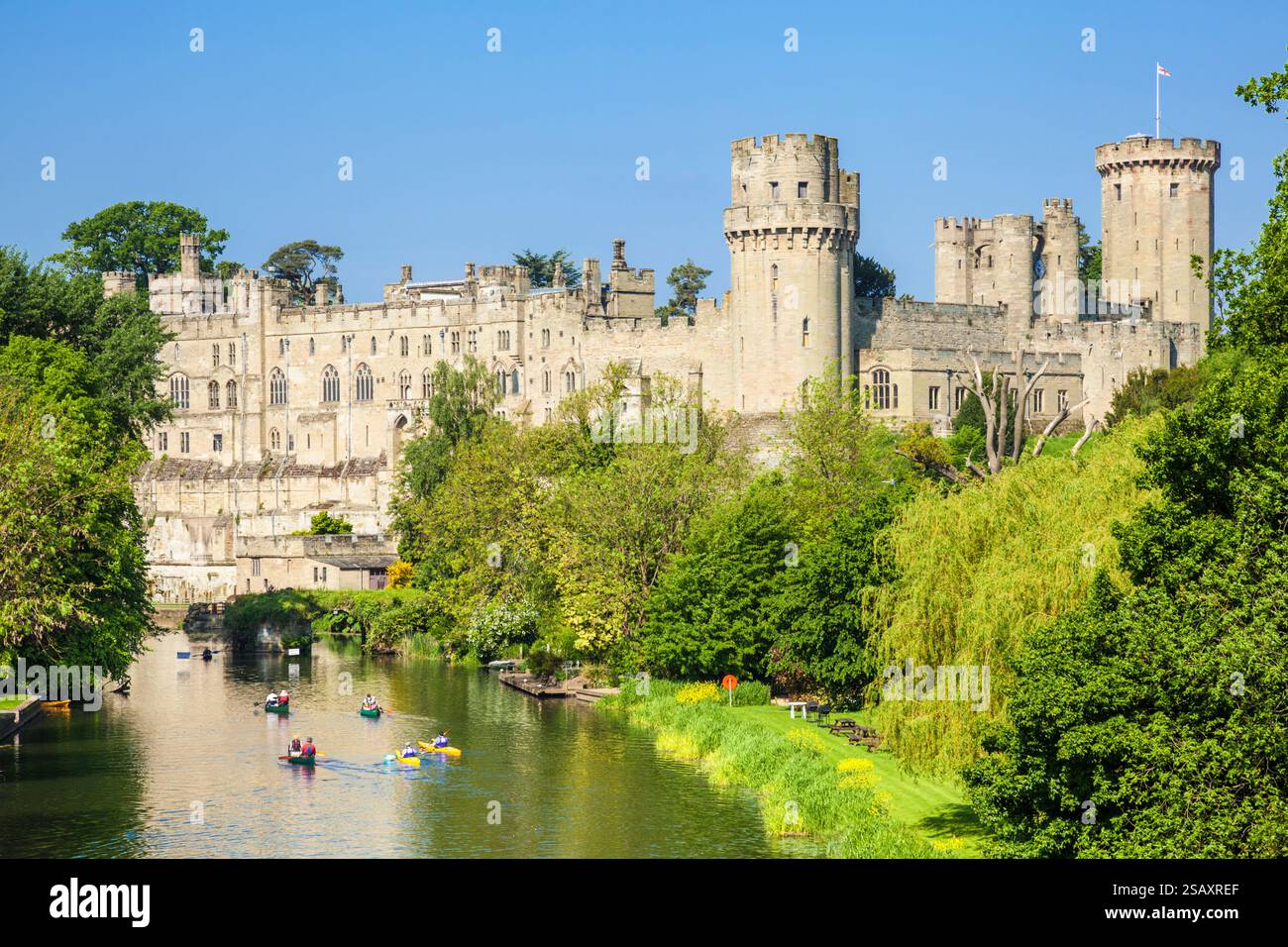 Warwick Castle River Avon mit Touristenkanus vorbei an Warwick Castle auf dem Fluss Avon Warwick Warwickshire England Großbritannien GB Europa Stockfoto