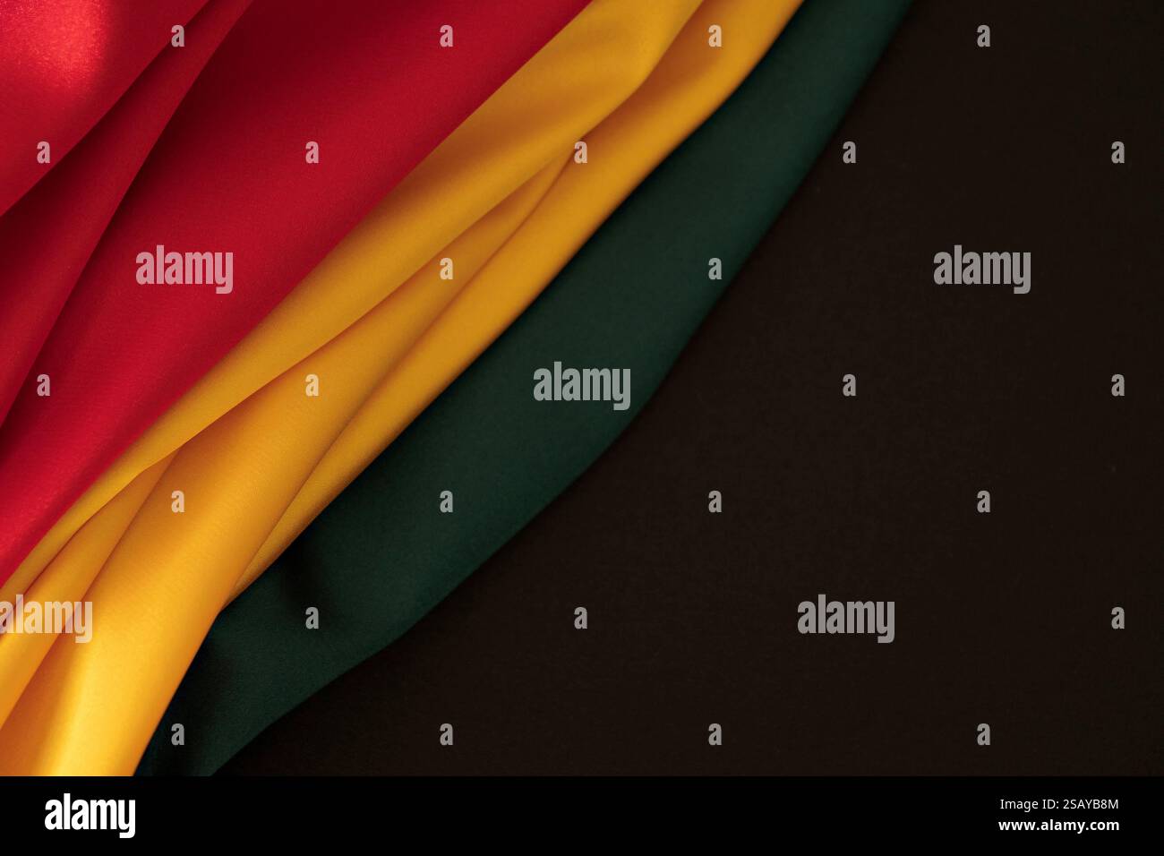 Hintergrund für schwarzen Monat. Rot, gelb, grüne Farben Vorhänge, Hintergrund Seidenfahne. Draufsicht Stockfoto
