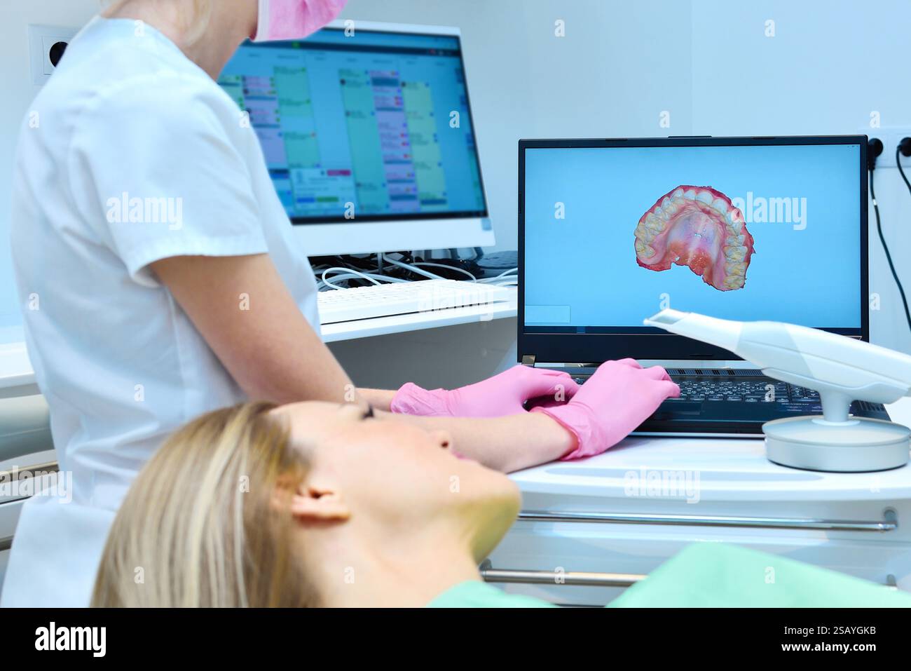 Zahnarzt zeigt auf Laptop-Bildschirm am zahnärztlichen 3D-Scan-Kiefer. Konzept für Gesundheitswesen und Stomatologie Stockfoto