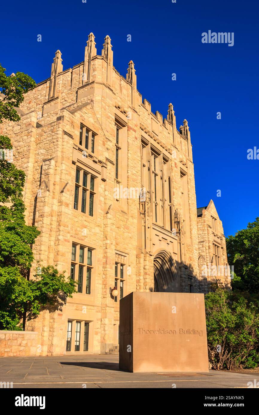 Das Gebäude ist alt und hat viele Fenster. Die Vorderseite des Gebäudes hat eine große Steinsäule Stockfoto