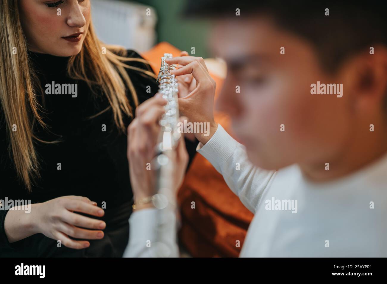 Zwei Personen, die eine Flöte in Nahaufnahme untersuchen und zusammenbauen Stockfoto