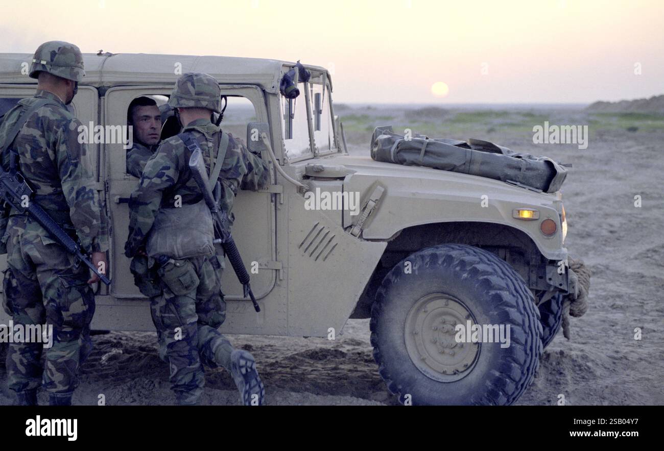 Erster Golfkrieg: 25. März 1991 bei Sonnenuntergang, an der Grenze zum Irak in Nordkuwait, Lt.Col. Michael J. Deegan, Kommandeur des Kavallerie-Bataillons 5-5 der 3. Panzerdivision, spricht mit Soldaten der US-Armee aus seinem Humvee. Stockfoto