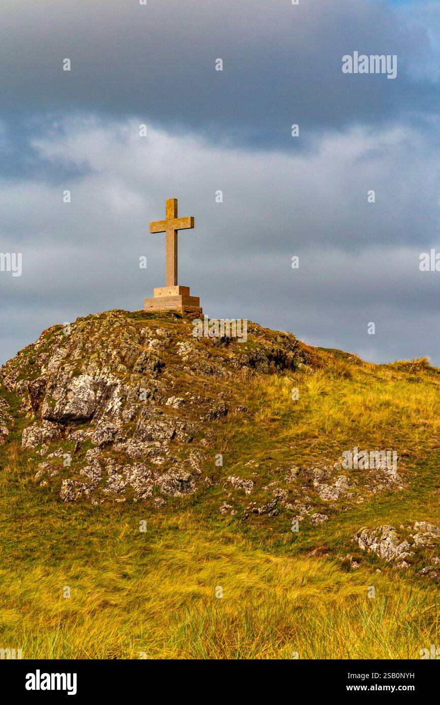 Hügelige Landschaft mit Kreuz auf Ynys Llanddwyn, einer kleinen Insel vor der Küste von Anglesey in Nordwales, Großbritannien. Stockfoto