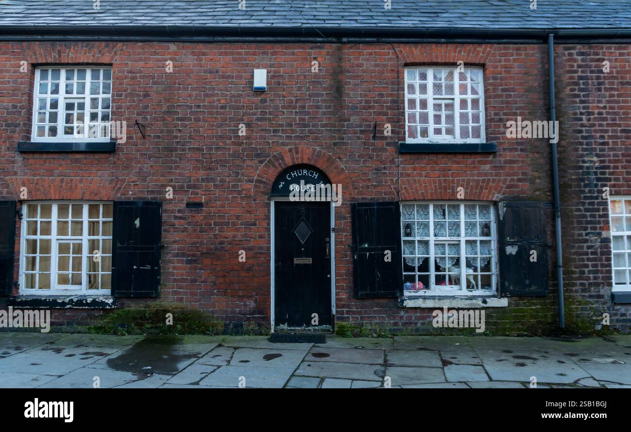 Eine Reihe von Reihenhäusern neben der St. Elphins Church in Warrington, Cheshire, Großbritannien Stockfoto