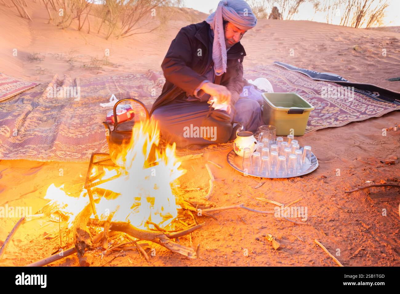 Tuareg-Mann bereitet Tee am Lagerfeuer in der algerischen sahara vor Stockfoto