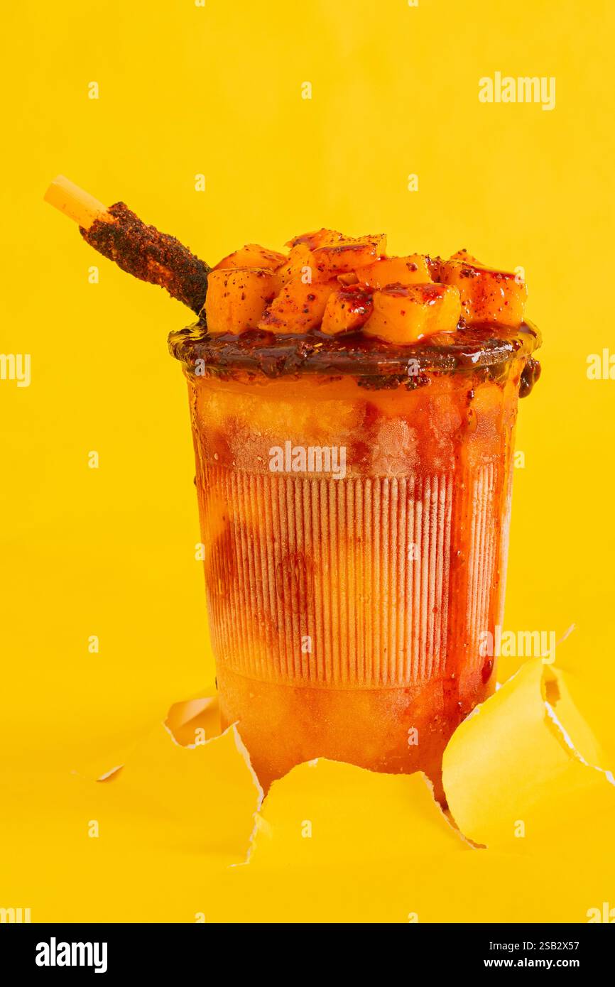 Mangonada, typischer mexikanischer Mango-Smoothie, isoliert auf gelbem Hintergrund. Kopierbereich. Stockfoto