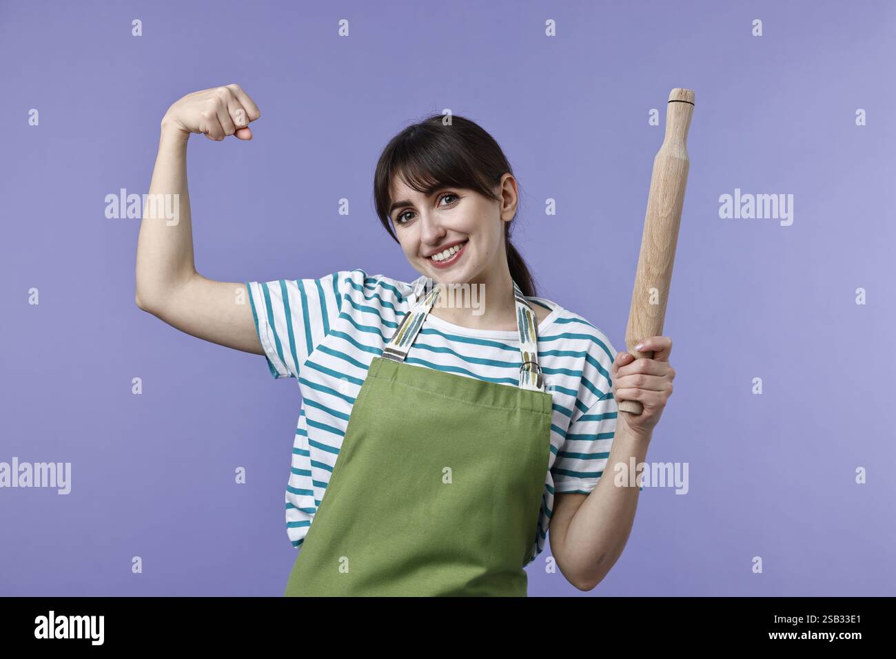 Eine Frau mit einem Pin, der Stärke auf violettem Hintergrund zeigt Stockfoto