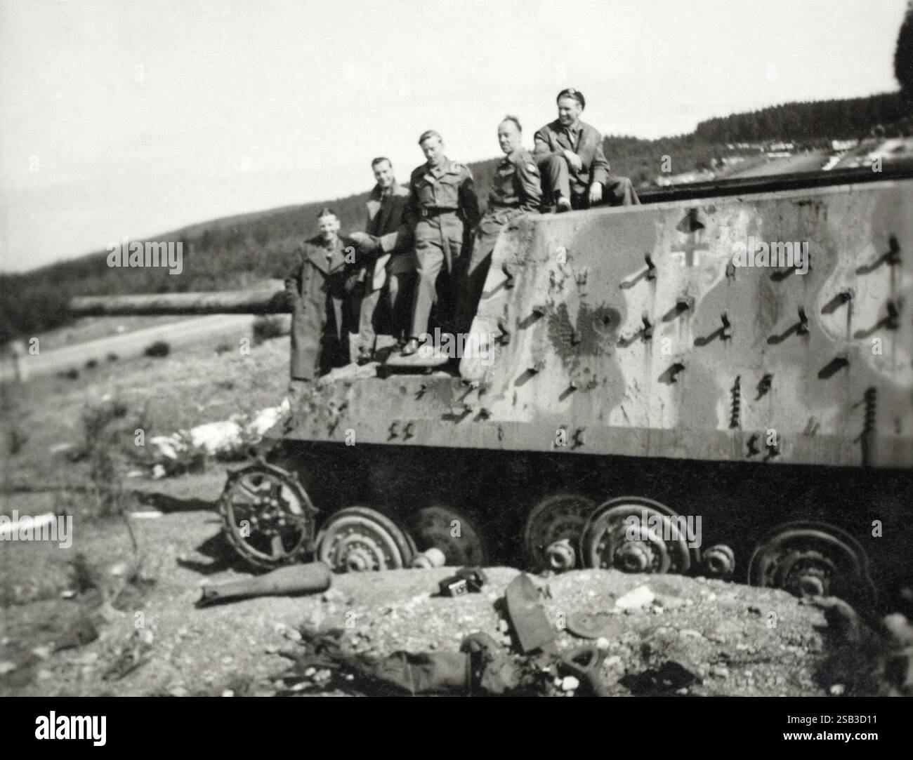 Ein zerstörter deutscher Panzerjäger Tiger Ausf. B-Panzerzerstörer aus dem Zweiten Weltkrieg mit britischen Soldaten des Royal Tank Regiment oben, April 1946. Stockfoto