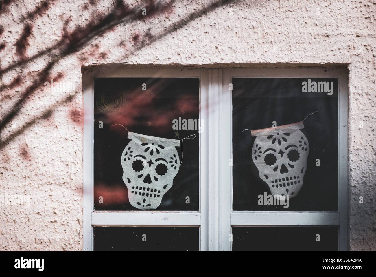 Papierausschnitte, mexikanische Volkskunst-Schädel im Winter im Fenster Stockfoto