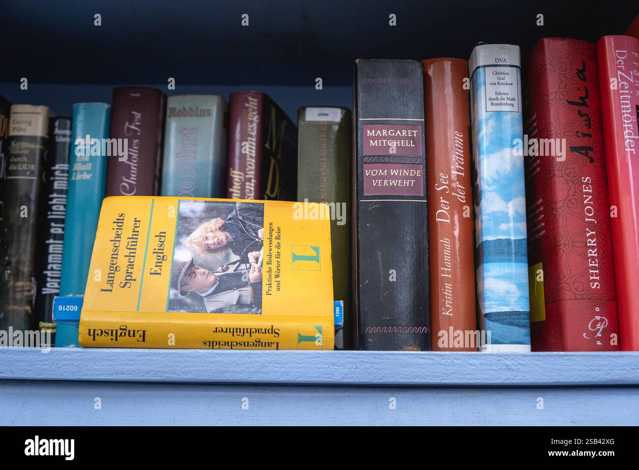 Ein Englisch-Deutsch-Wörterbuch in einem Regal mit kostenlosen Büchern Stockfoto