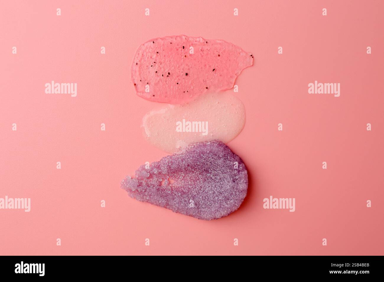 Abstriche von Körperpeelungen auf hellrosa Hintergrund, Draufsicht Stockfoto