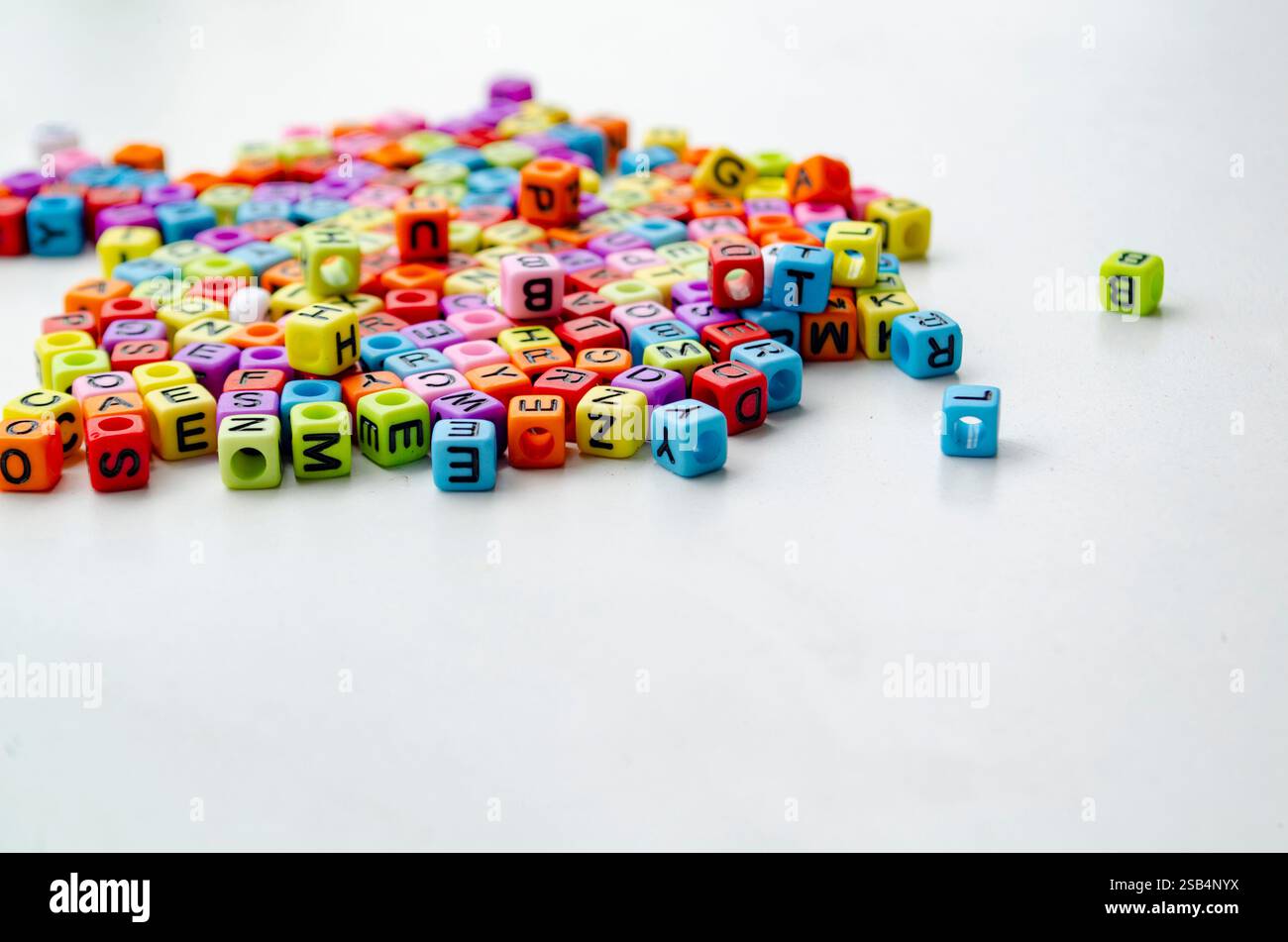 Bunte Plastikperlen mit Buchstaben darauf. Stockfoto