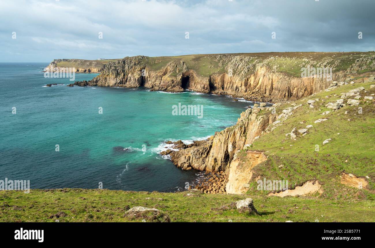 Felsige Klippen und Küste, vom südkornischen Küstenpfad in der Nähe von Pendower Buchten aus gesehen, mit Land's End in der Ferne, Cornwall, England, Großbritannien Stockfoto
