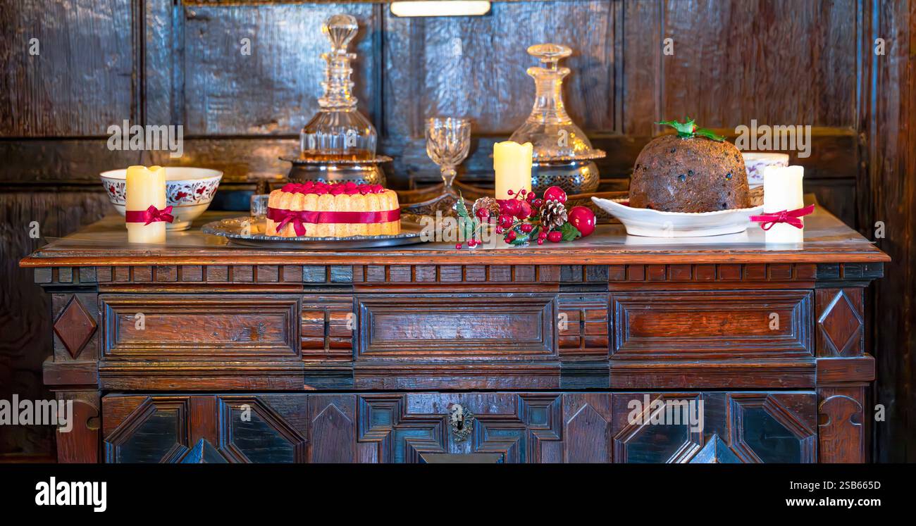 Festliche Dessertpräsentation auf einem antikem Sideboard aus Holz Stockfoto