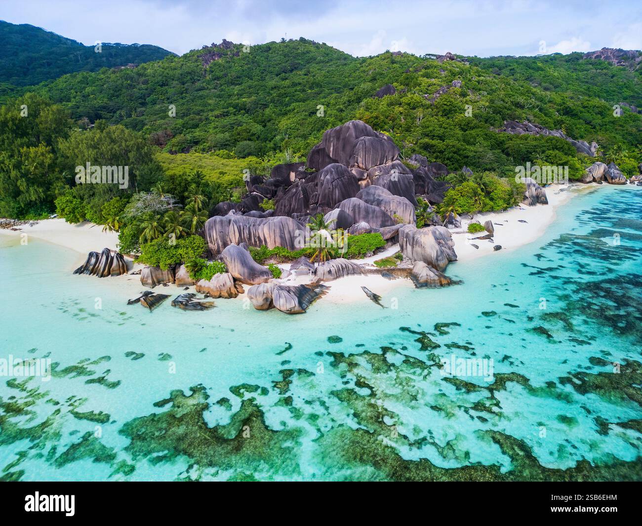 Blick aus der Vogelperspektive auf Anse Source D'Argent auf La Digue, Seychellen, mit üppigen grünen Wäldern, berühmten Granitfelsen, weißem Sandstrand und klarem Wasser Stockfoto