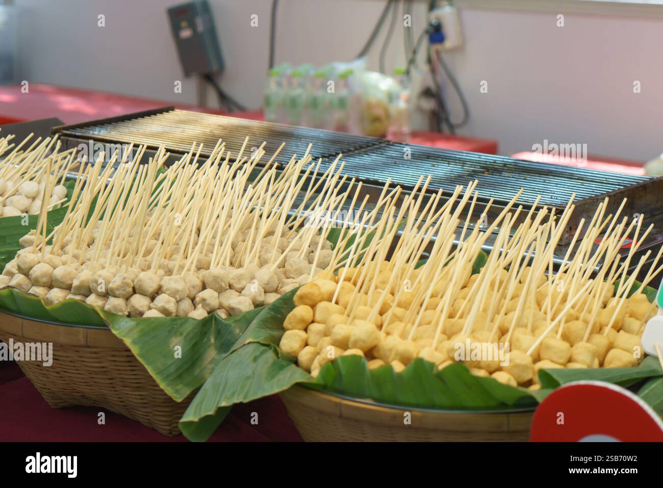 Lebendige Präsentation traditioneller gegrillter Fleischspieße, die auf Tabletts mit Bananenblättern ordentlich angeordnet sind, auf einem lokalen Lebensmittelmarkt. Die Sortimentskästen gehen Stockfoto Lebendige Präsentation traditioneller gegrillter Fleischspieße, die auf Tabletts mit Bananenblättern ordentlich angeordnet sind, auf einem lokalen Lebensmittelmarkt. Die Sortimentskästen gehen Stockfoto