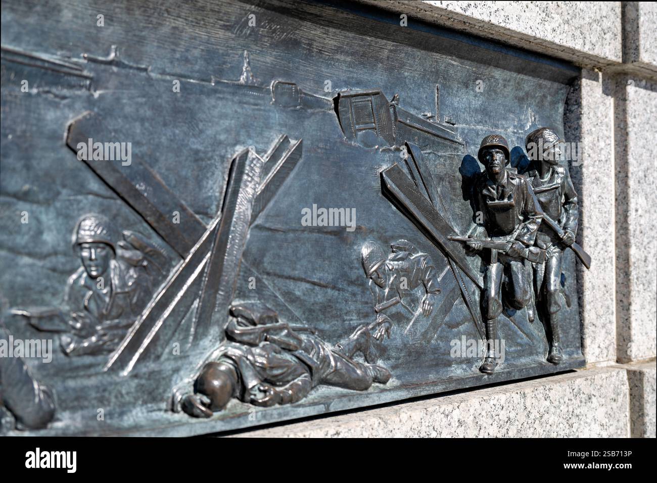 WASHINGTON DC – das bronzene Basrelief am National World war II Memorial zeigt alliierte Truppen, die während der D-Day-Invasion am 6. Juni 1944 an den Küsten Frankreichs landen. Die Skulptur, die von Ray Kaskey geschaffen wurde, zeigt Landungsboote, die Truppen an die Küsten der Normandie liefern, inmitten deutscher Feuer- und Strandhindernisse im Rahmen der Operation Overlord. Dieses Kunstwerk ist eines von 24 Bronze-Basreliefs entlang des zeremoniellen Eingangs der Gedenkstätte, die Szenen von der Heimatfront und den Schlachtfeldern des Atlantic Theaters illustrieren. Stockfoto