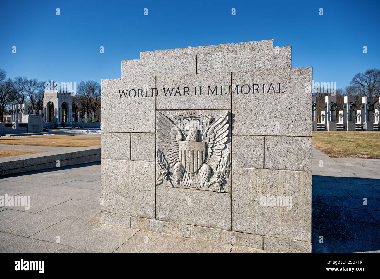 WASHINGTON DC – Ein Basreliefschild mit Adler, Pfeilen und Olivenzweigen ist in die Granitblöcke am östlichen Eingang des National World war II Memorial gemeißelt. Das skulpturale Detail spiegelt die traditionelle amerikanische Militärsymbolik wider. Das geschnitzte Emblem markiert einen der Haupteingänge der National Mall. Stockfoto