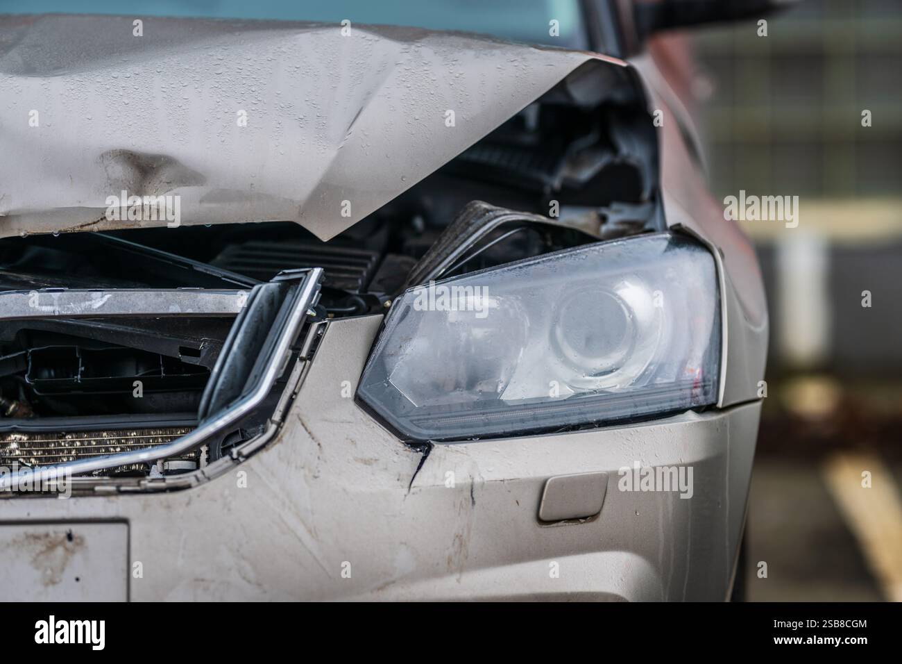Beschädigtes silbernes Auto auf dem Parkplatz mit Frontalkollision Stockfoto