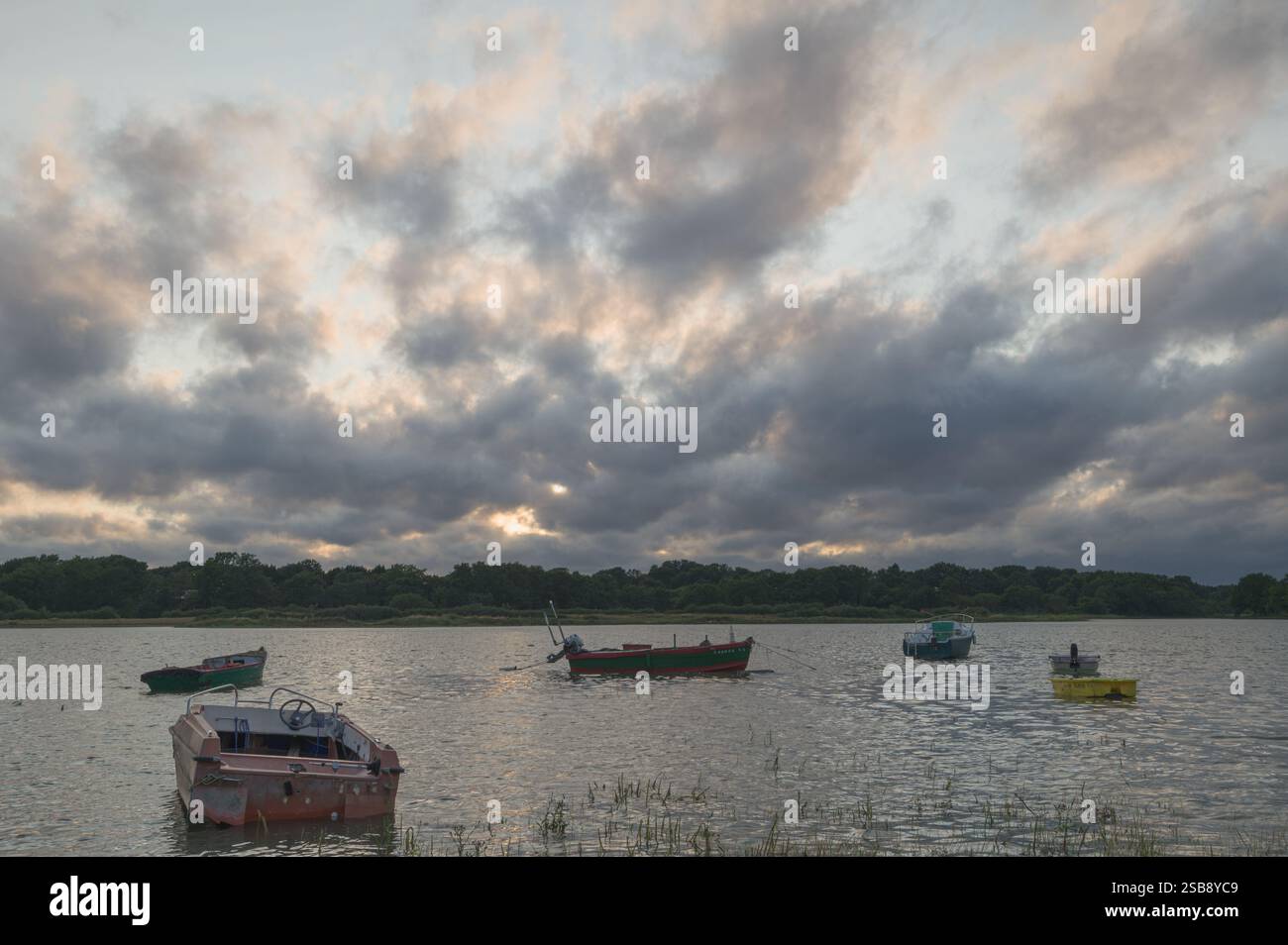 Farbenfroher Himmel bei Sonnenuntergang in Morbihan mit dem Golf und Booten im Vordergrund Stockfoto
