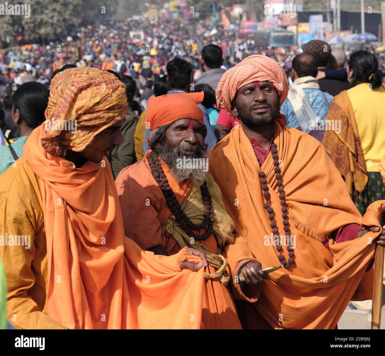 Eine lebhafte Versammlung blinder Krishna sadhus sammelt anmutig Almosen, verkörpert Hingabe und Tradition im Maha Kumbh Mela in Prayagraj, Indien. Stockfoto