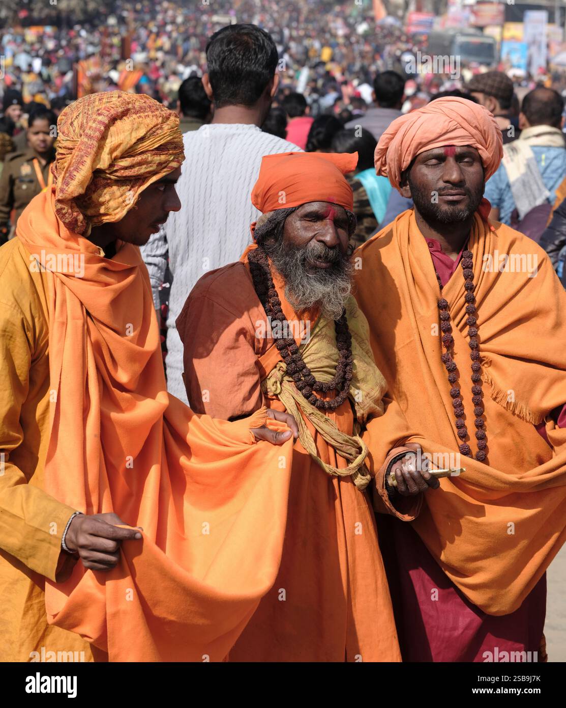 Eine lebhafte Versammlung blinder Krishna sadhus sammelt anmutig Almosen, verkörpert Hingabe und Tradition im Maha Kumbh Mela in Prayagraj, Indien. Stockfoto