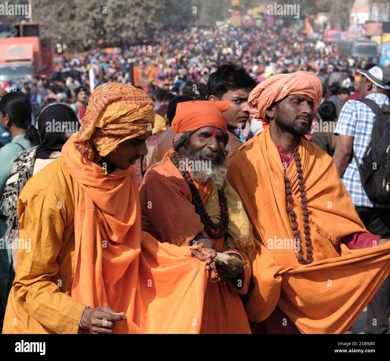 Eine lebhafte Versammlung blinder Krishna sadhus sammelt anmutig Almosen, verkörpert Hingabe und Tradition im Maha Kumbh Mela in Prayagraj, Indien. Stockfoto