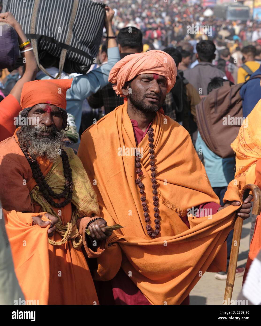 Eine lebhafte Versammlung blinder Krishna sadhus sammelt anmutig Almosen, verkörpert Hingabe und Tradition im Maha Kumbh Mela in Prayagraj, Indien. Stockfoto