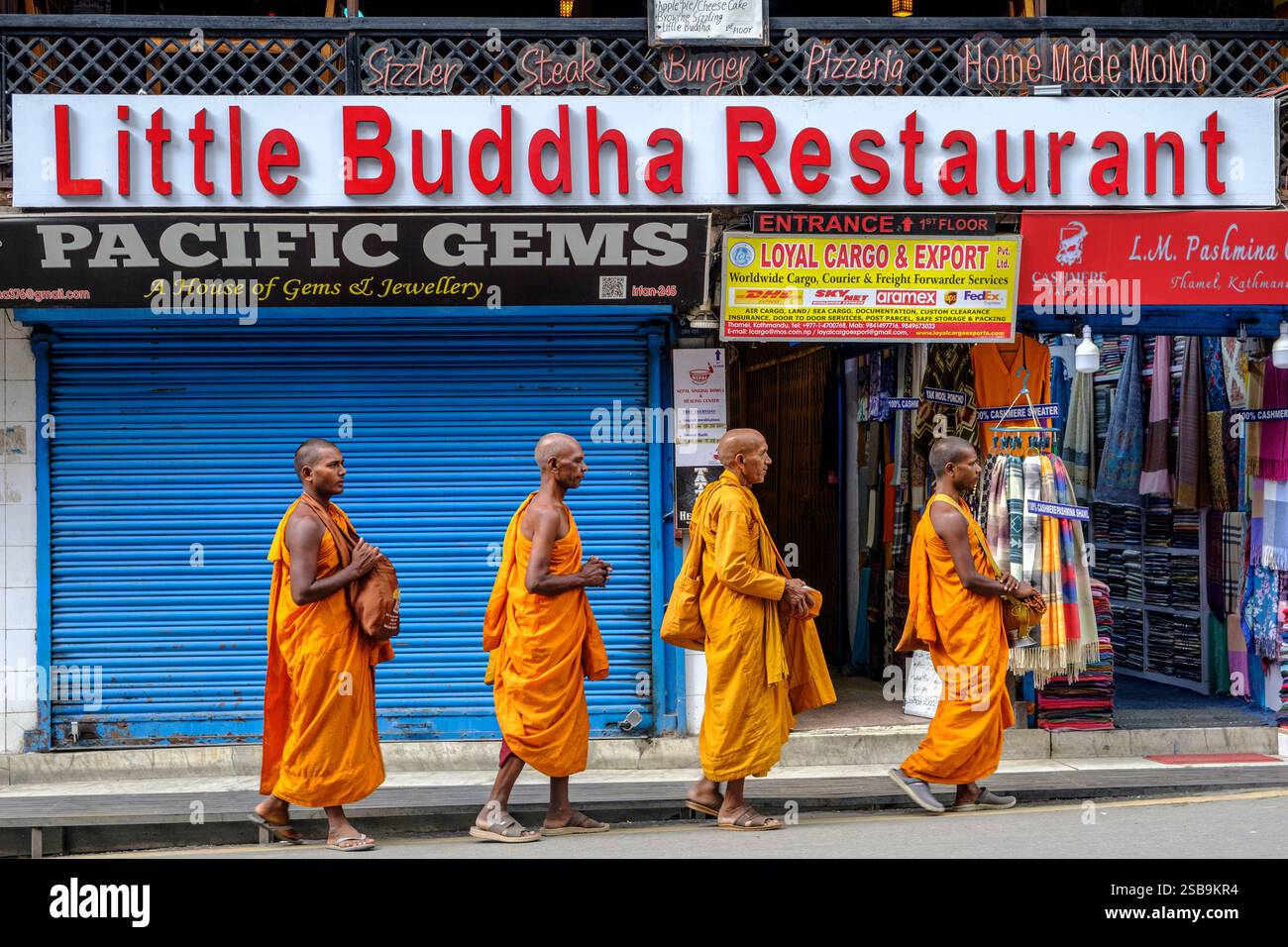 Mönche gehen an einem Restaurant in Thamel, Kathmandu, vorbei. Stockfoto