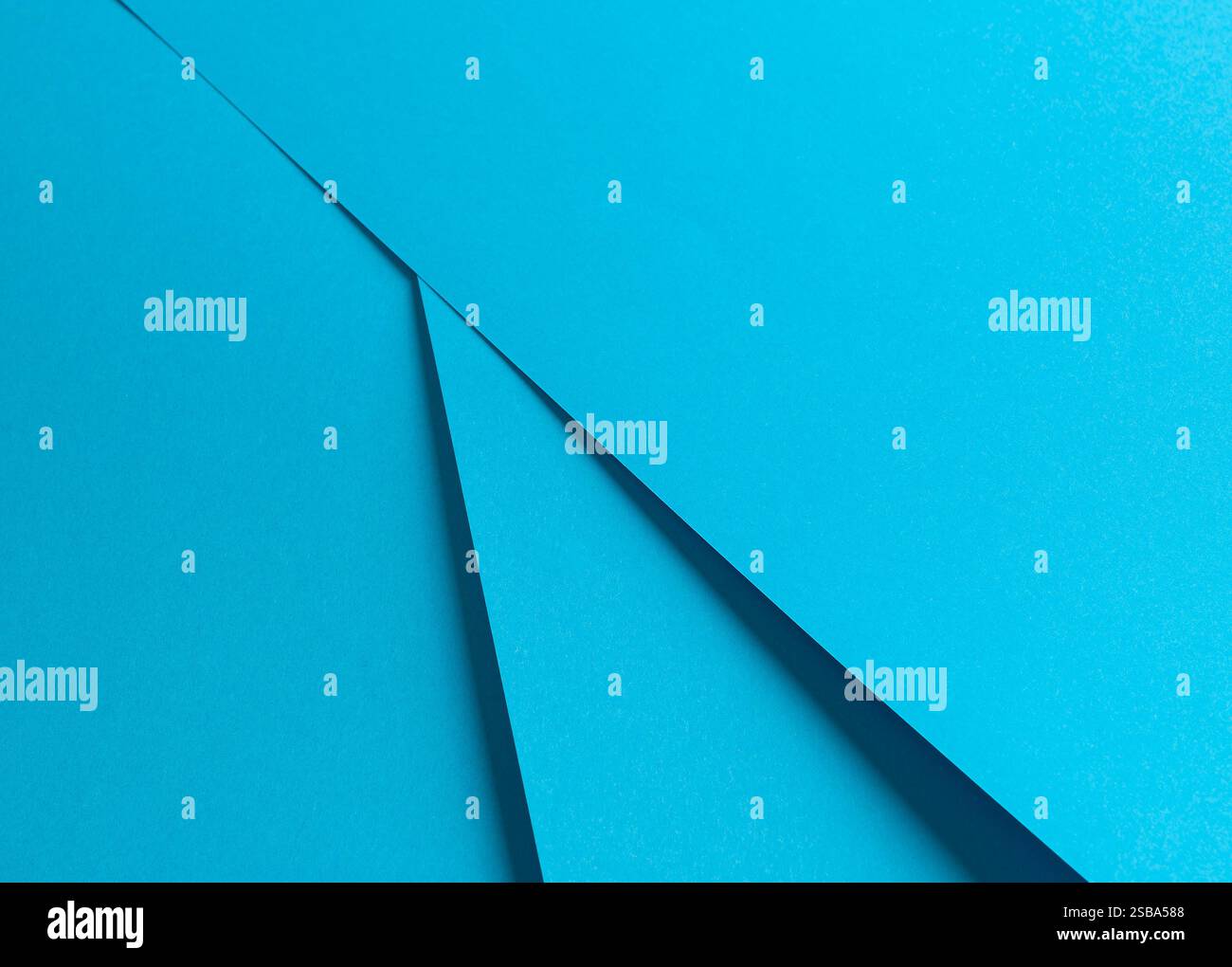 Blauer Papierhintergrund mit glatter, matter Oberfläche und sich überlappenden geometrischen Schichten. Zarte Pastelltöne und scharfe Kontraste sorgen für eine lebendige, e Stockfoto