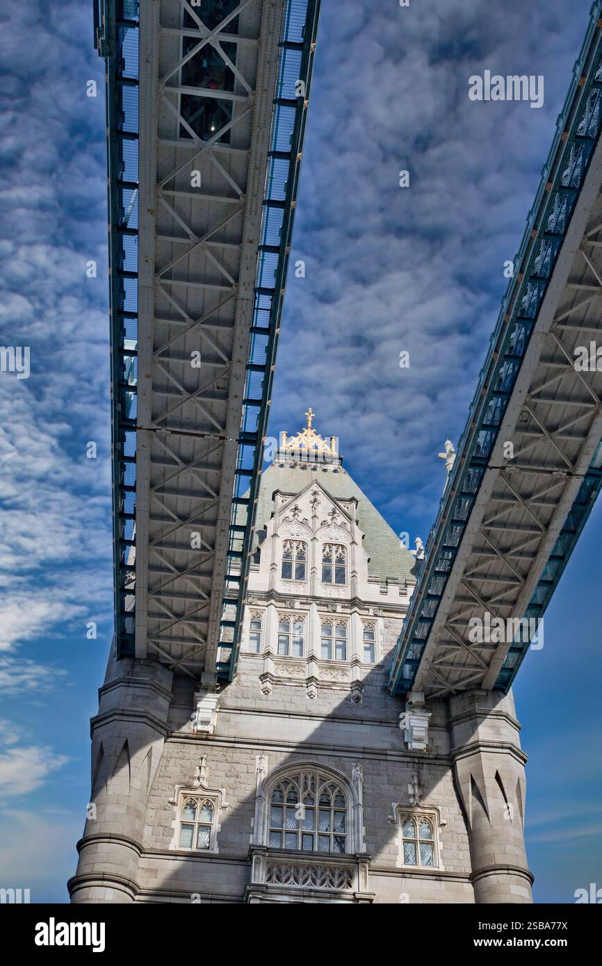 Flacher Blick auf die Innenstruktur der Tower Bridge mit Blick auf die hohen Gehwege und das Mauerwerk der zentralen Türme gegen eine teilweise Wolke Stockfoto