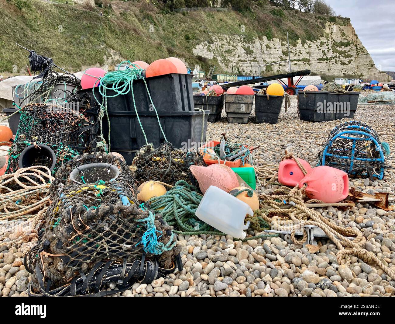 Hummertöpfe, Fisihing-Ausrüstung, farbenfrohe Bojen und Seile am Strand bei Beer, Devon - Smartphone-aufgenommenes Stockfoto
