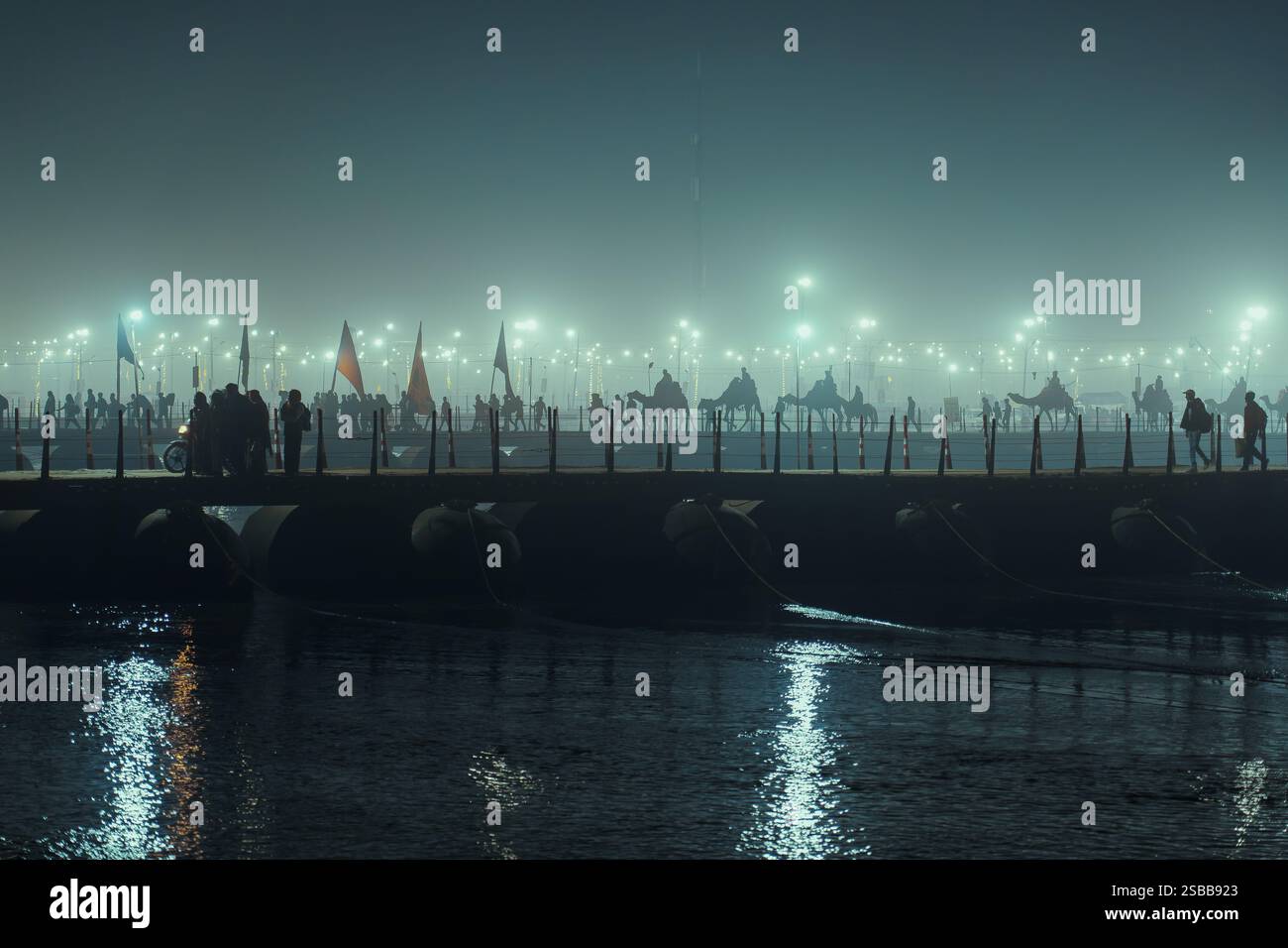 Prayagraj, Uttar Pradesh, Indien, 11. Januar 2025. Pilger, die über eine nebelbedeckte Pontonbrücke in Mahakumbh Mela spazieren, schaffen eine ruhige Atmosphäre Stockfoto