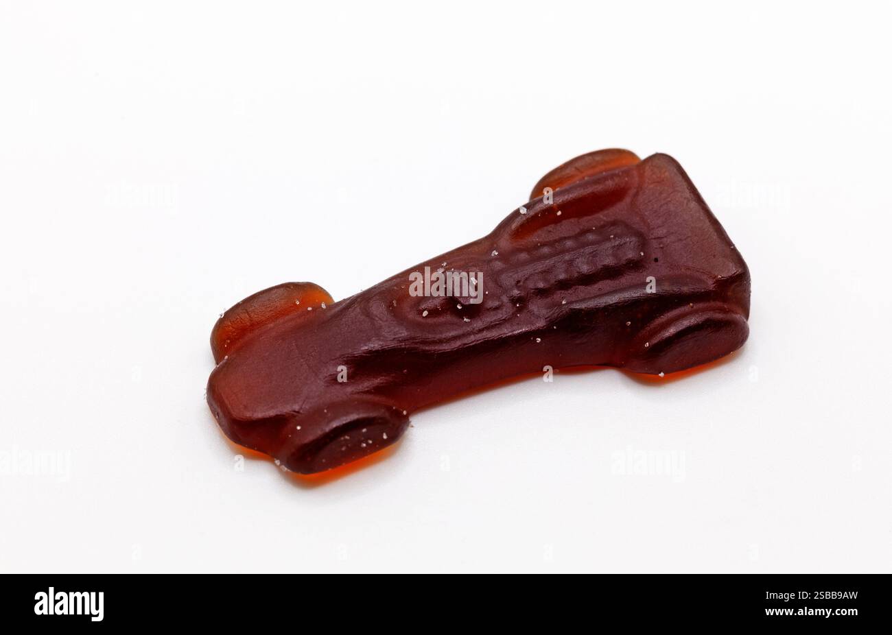 Ein dunkelbraunes, autoförmiges Bonbon mit Cola-Geschmack, das einem Fahrzeug ähnelt. Stockfoto