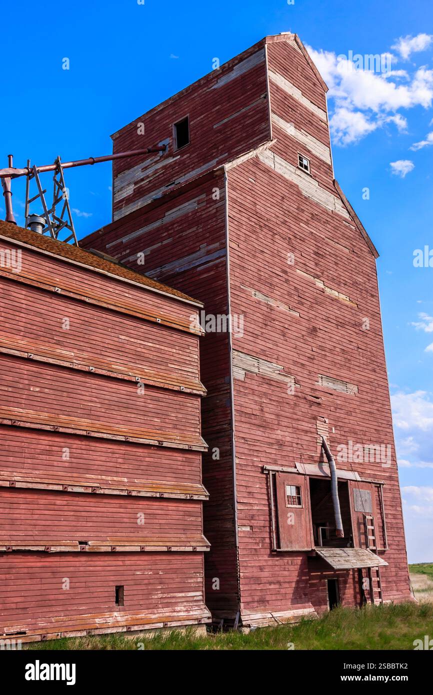 Ein rotes Backsteingebäude mit einem großen Kamin. Das Gebäude ist alt und hat ein rustikales Aussehen Stockfoto