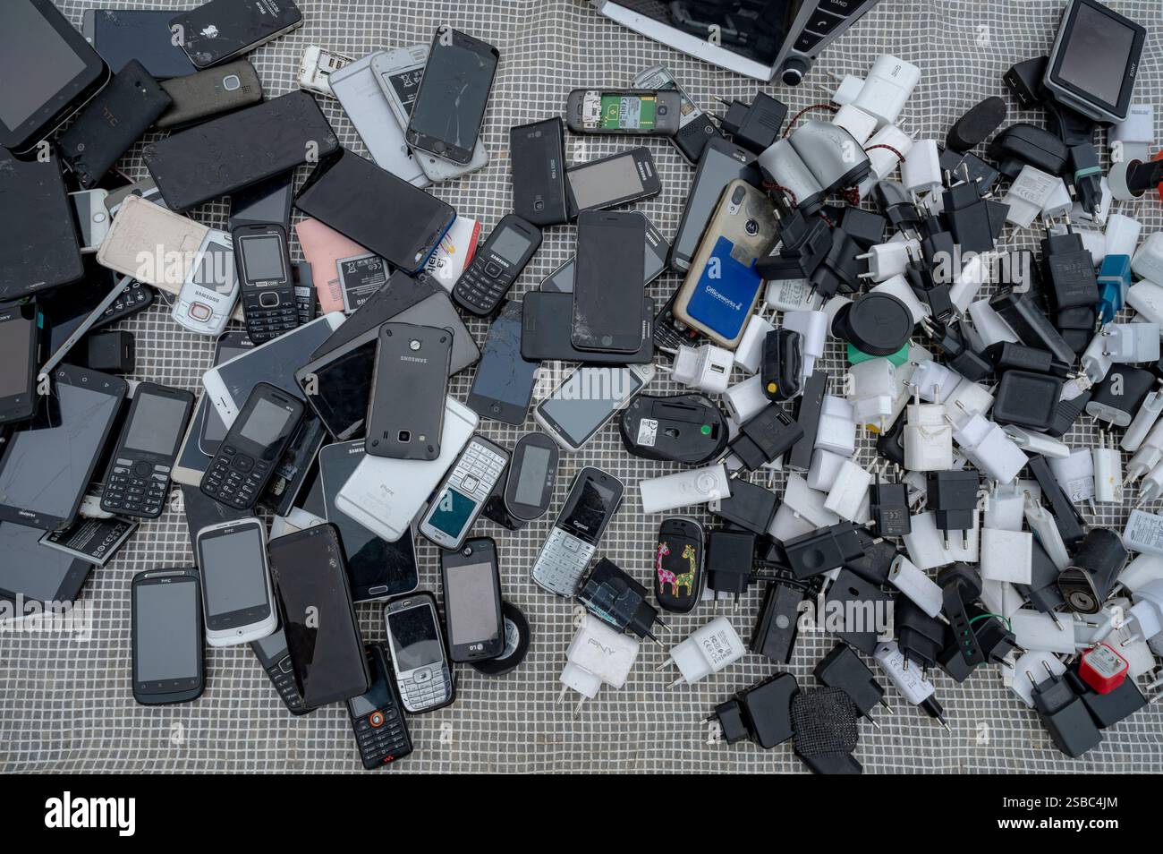 Hunedoara, Rumänien - 25. Januar 2025: Menschenmenge und verschiedene Gegenstände, Spielzeug, Werkzeuge und Elektronik auf einem Flohmarkt. Stockfoto