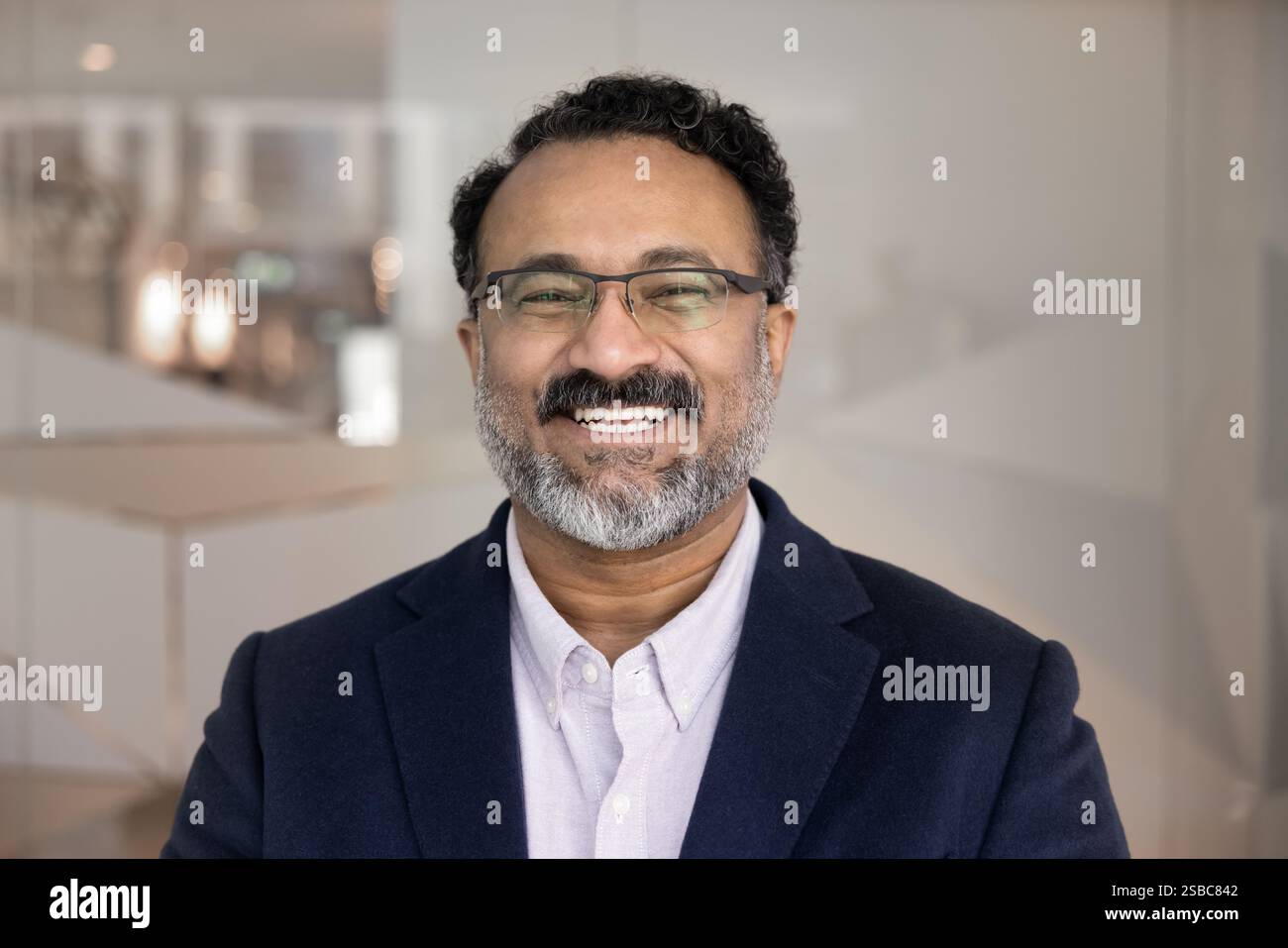 Eine fröhliche, ältere indische Geschäftsführerin posiert für ein Porträt Stockfoto