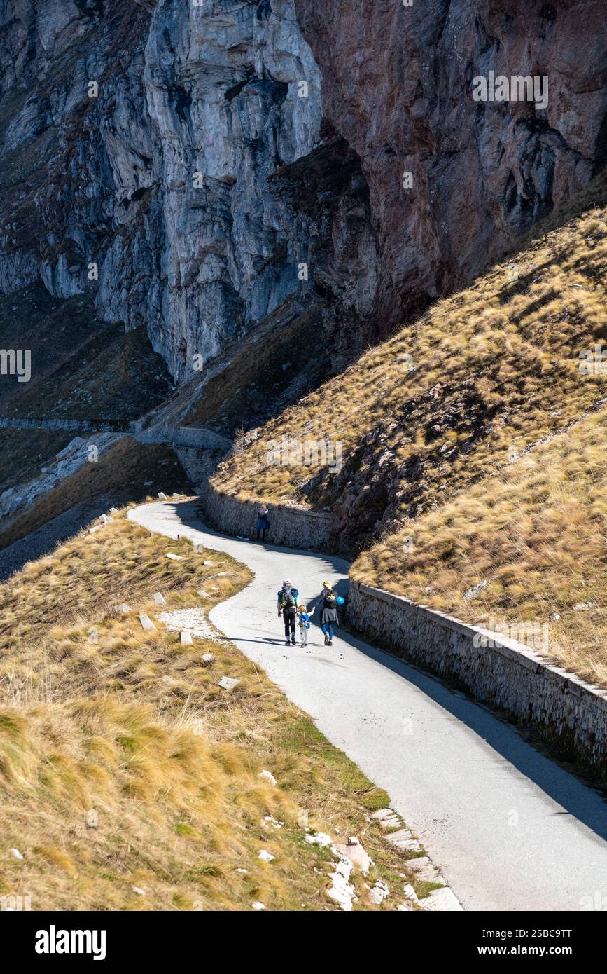 Wanderer, die auf einer Bergstraße in der Nähe einer steilen Klippe in den slowenischen alpen spazieren. Mount Mangart, Slowenien Stockfoto