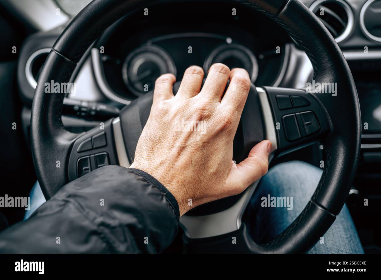 Hupendes Autohorn, männliche Hand am Autolenkrad an kalten Wintertagen, selektiver Fokus Stockfoto