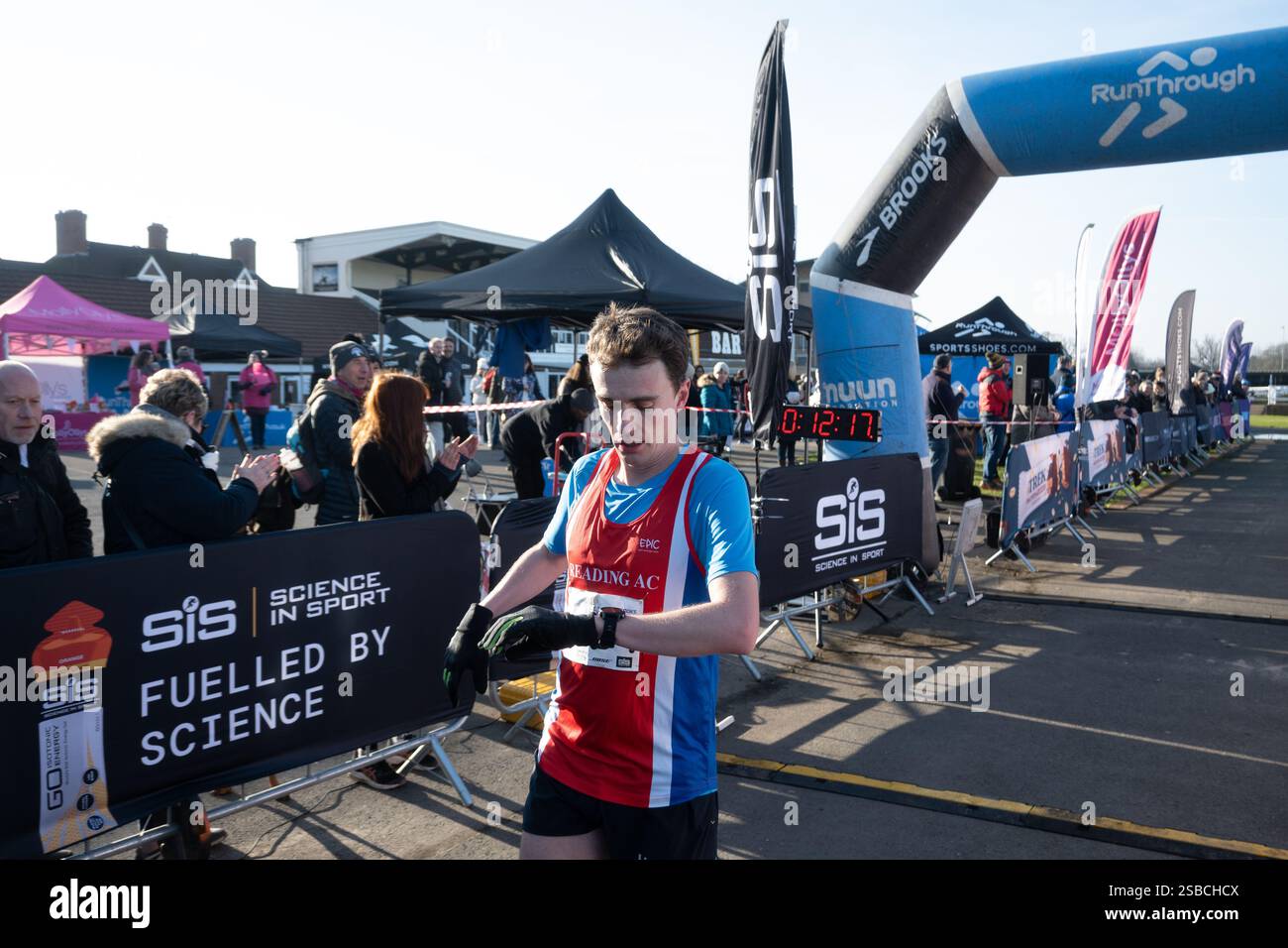 Der Sieger überprüft seine Uhr beim Warwick Half Marathon 2025 in Warwickshire, Großbritannien Stockfoto
