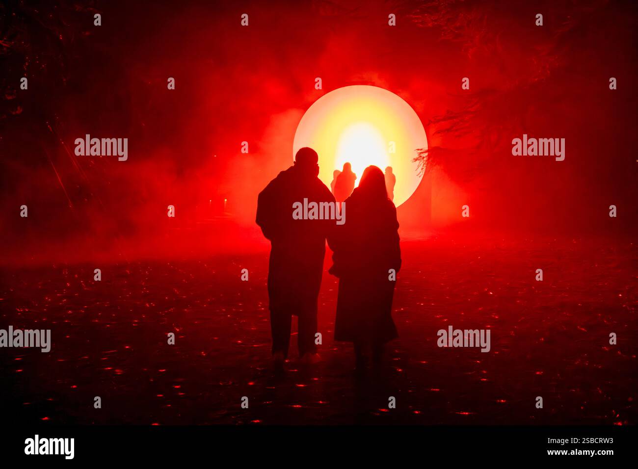 Bezaubernde Nachtkulisse von Mailand Lichtzyklen: Lebendige Kunstinstallation, die den Wald von Idroscalo mit faszinierendem Blau und warmen Leuchten beleuchtet Stockfoto