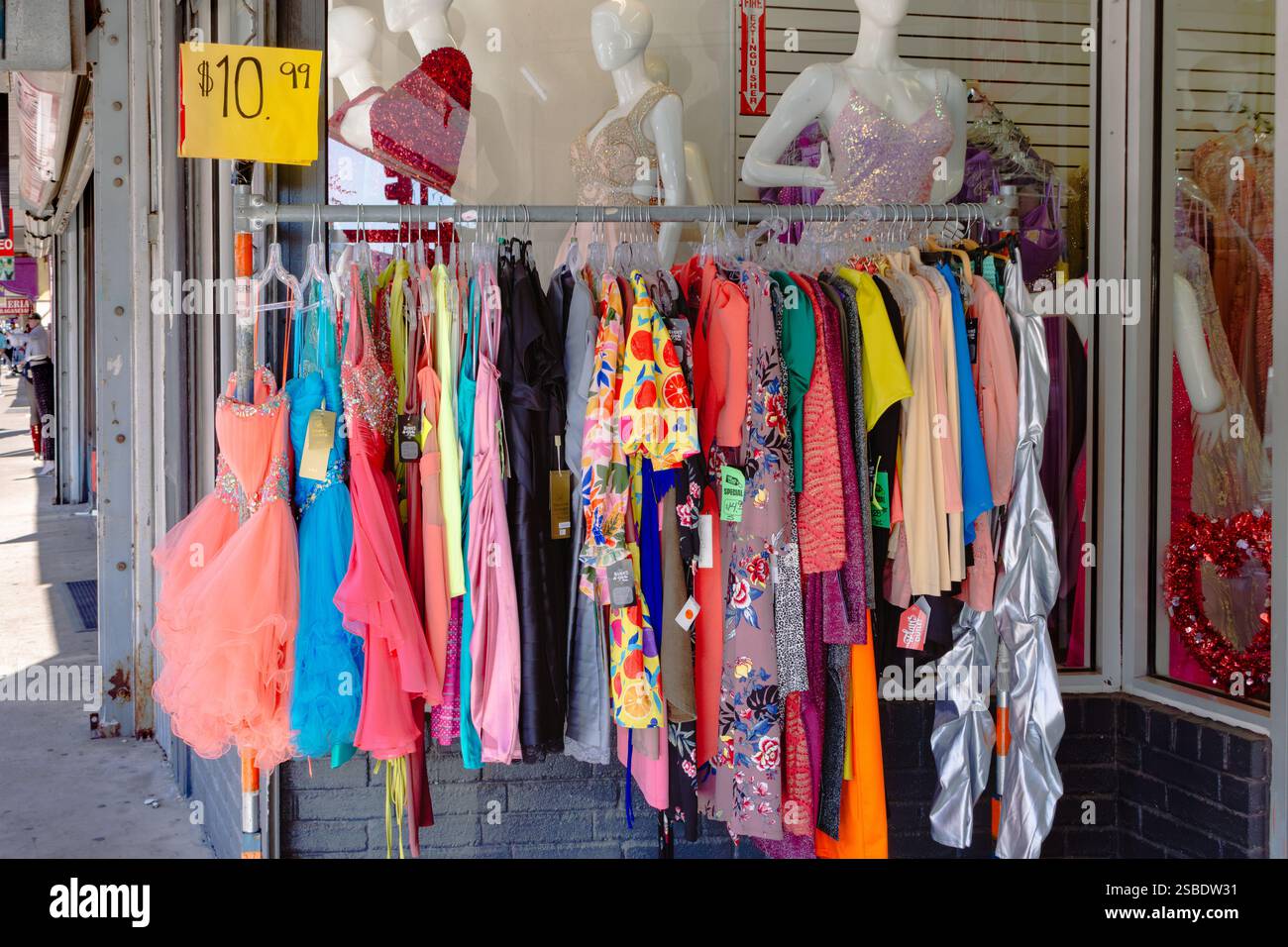 Bunte, preiswerte Damenbekleidung auf dem Bürgersteig vor einem Bekleidungsgeschäft im Zentrum von McAllen, Hidalgo County, Texas, USA. Stockfoto