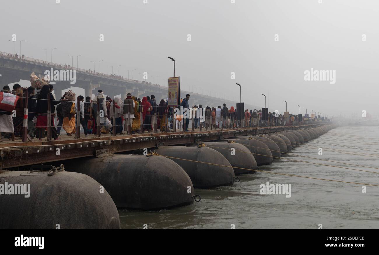 Pilger, die während der Maha Kumbh Mela in Prayagraj 2025 die Brücke in Richtung Sangam überqueren Stockfoto