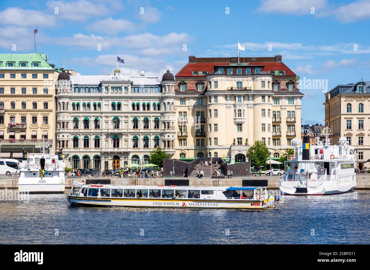 Ein Sightseeing-Boot des schwedischen Tourismusunternehmens Strömma, das auf dem Norrström in Stockholm, Schweden, vor historischen Gebäuden segelt Stockfoto